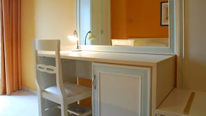 A room with a white desk, a chair, a cabinet, and a mirror. - Hotel Michelangelo (Teramo)
