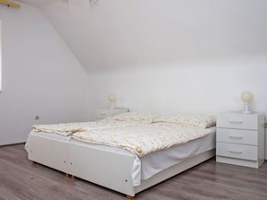 A bedroom with a bed, two bedside tables, and a nightstand.