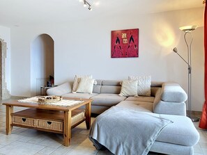 A living room with a sofa, a coffee table, and a floor lamp.
