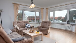 Ein geräumiges Wohnzimmer mit zwei Sofas, einem Couchtisch und einem Kamin.