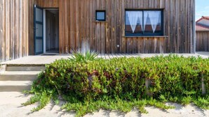 A wooden building with a large window, a door, and a small window. - Les Mouettes by Interhome (Mimizan)