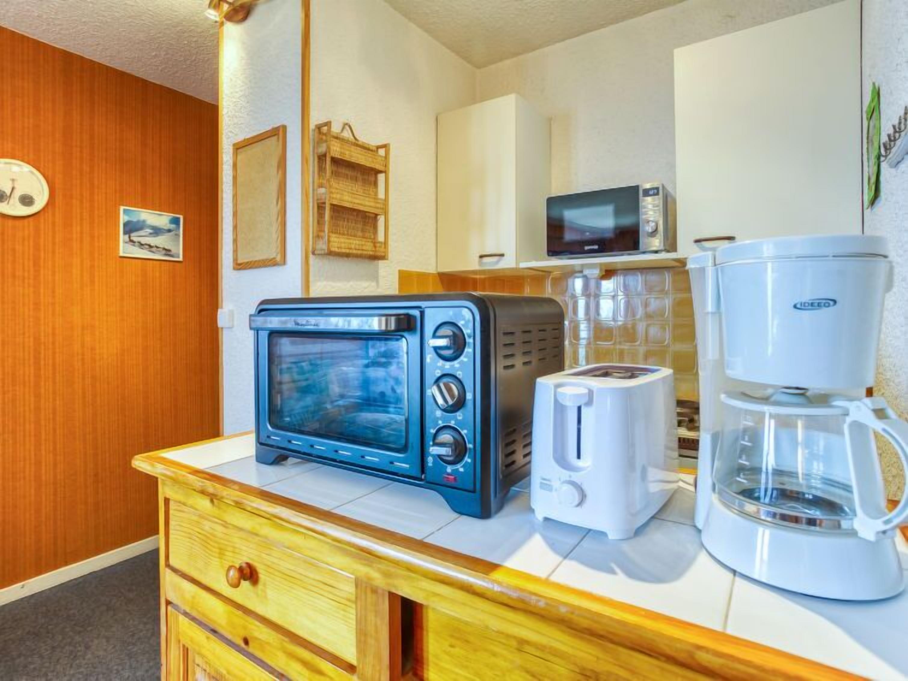 A kitchenette with a toaster, coffee maker, and microwave.