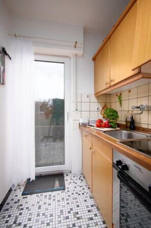 Een koelkast, een microgolfoven, een oven, kookgerei, borden en bestek