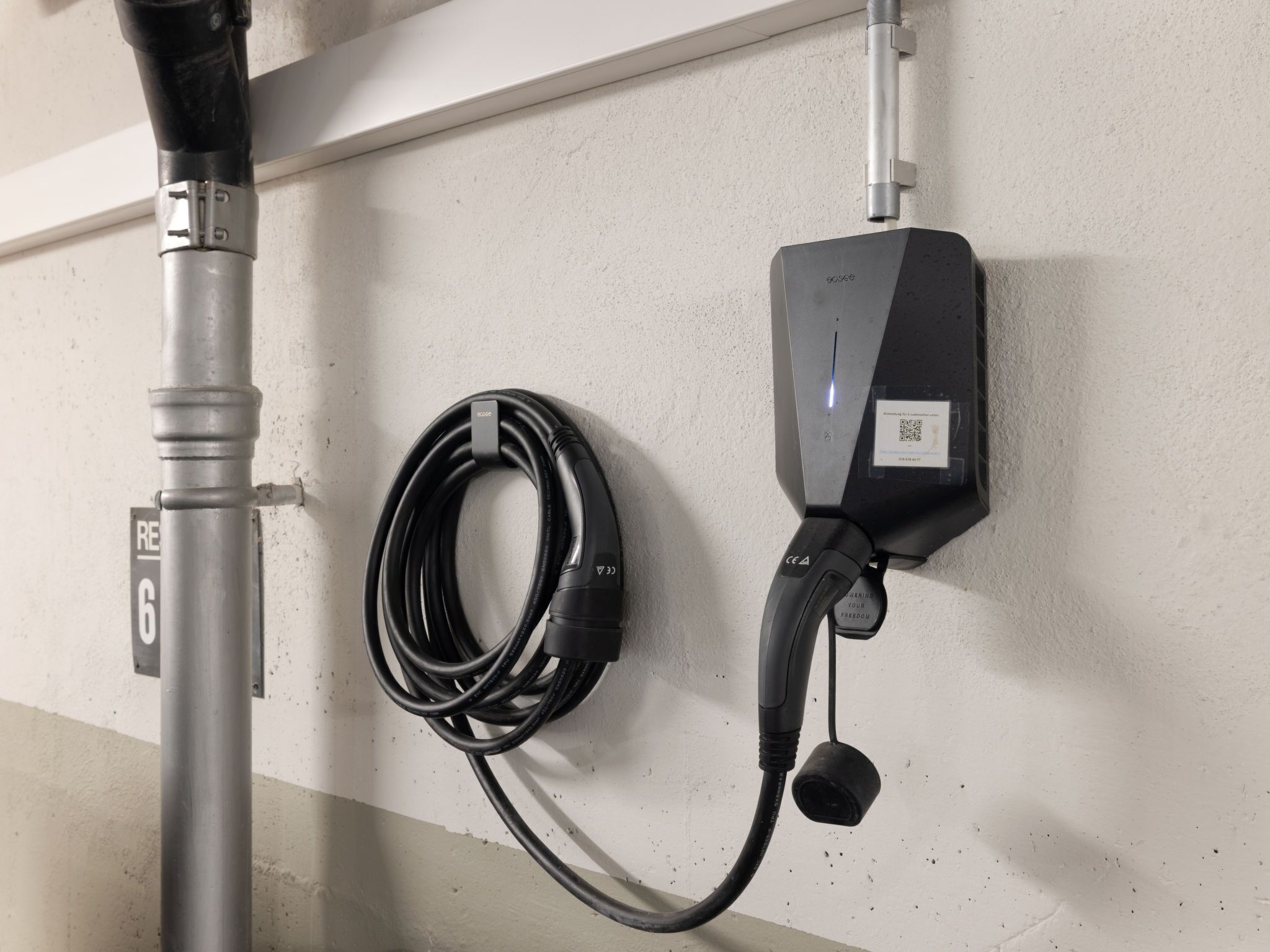 A charging station with a cable and a power outlet on a wall.