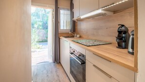 Een moderne keuken met een houten aanrecht, inbouwkeuken, een koffieapparaat en uitzicht op de omgeving.