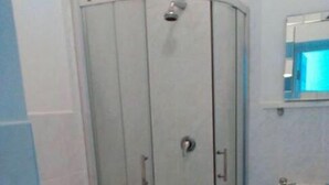 Un baño con ducha acristalada, inodoro y lavabo.