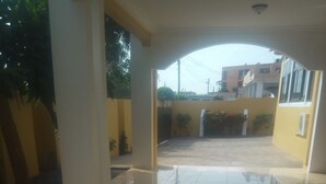 Un patio abierto con suelo de baldosas y vista a un edificio residencial al fondo.