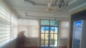Un vestíbulo con sofá, mesa de centro, refrigerador y una planta en maceta.