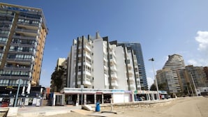 A beachfront hotel with multiple floors, a covered outdoor area, and a sandy beach in the foreground. - Europa I by Interhome (Calpe/Calp)