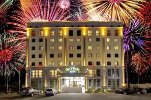 A hotel with a central entrance, multiple floors, and a well-lit facade. - Garden Hotel & Spa (Bishkek)