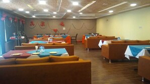 A dining area with booths and tables, some with blue tablecloths.