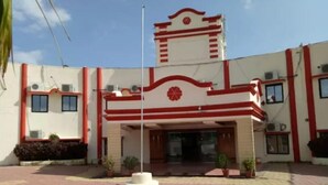 A building with a symmetrical facade, a central entrance with a staircase, and a flagpole.