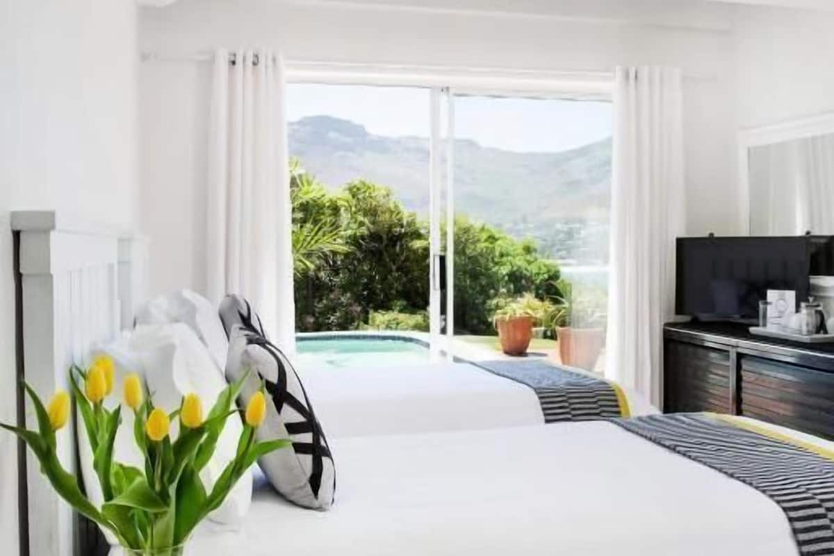 Un dormitorio con una cama grande, televisor y vistas a un paisaje montañoso.