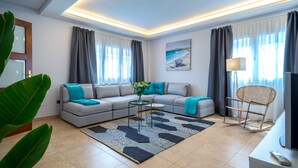 Ein modernes Wohnzimmer mit einer Couch, einem Couchtisch und einem Fernseher.