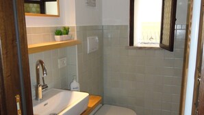 A bathroom with a sink, mirror, and toilet. - Casa Penelope Sperlongaresort (Sperlonga)