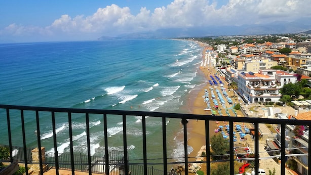 A coastal town with a beach, hotel, and ocean view.