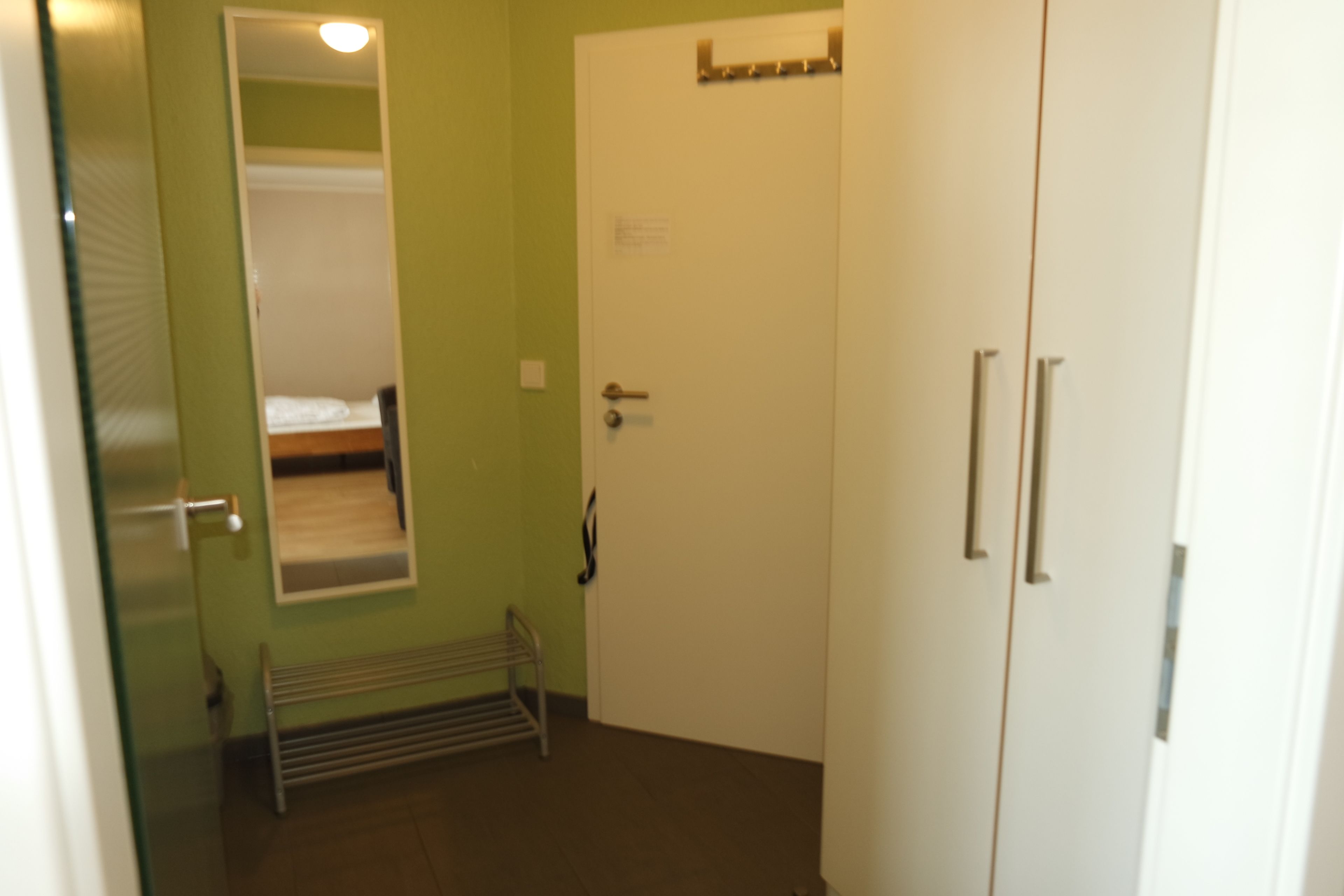 A room with a bed, a door, and a radiator.