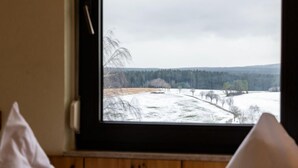 A room with a window overlooking a snowy landscape. - Bergliebe (G 103) by Interhome (Dittishausen)