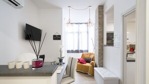 Un espacio habitable moderno con cocina, zona de estar con banco y mesa de comedor.