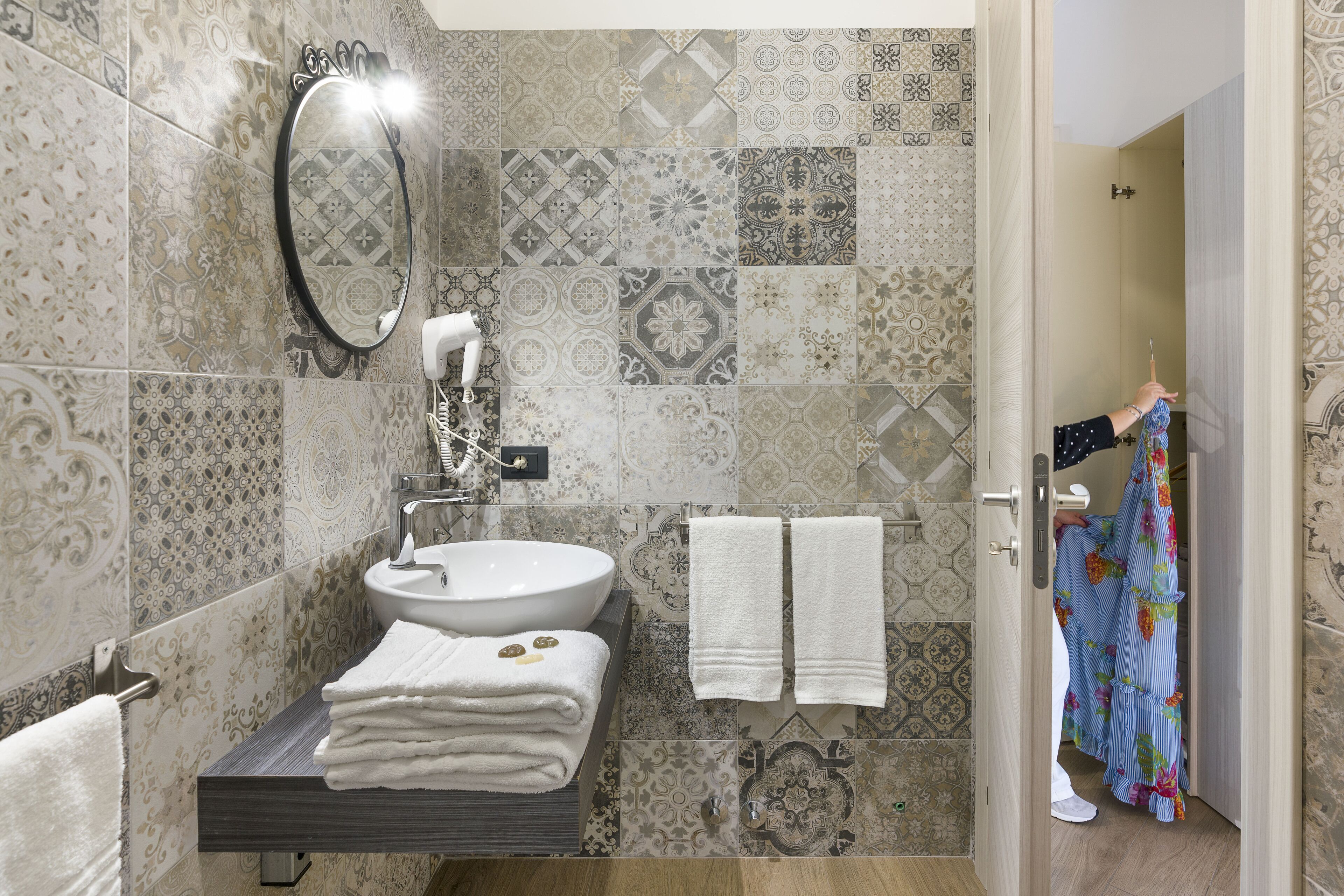 A bathroom with a sink, mirror, and towels.