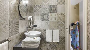A bathroom with a sink, mirror, and towels.