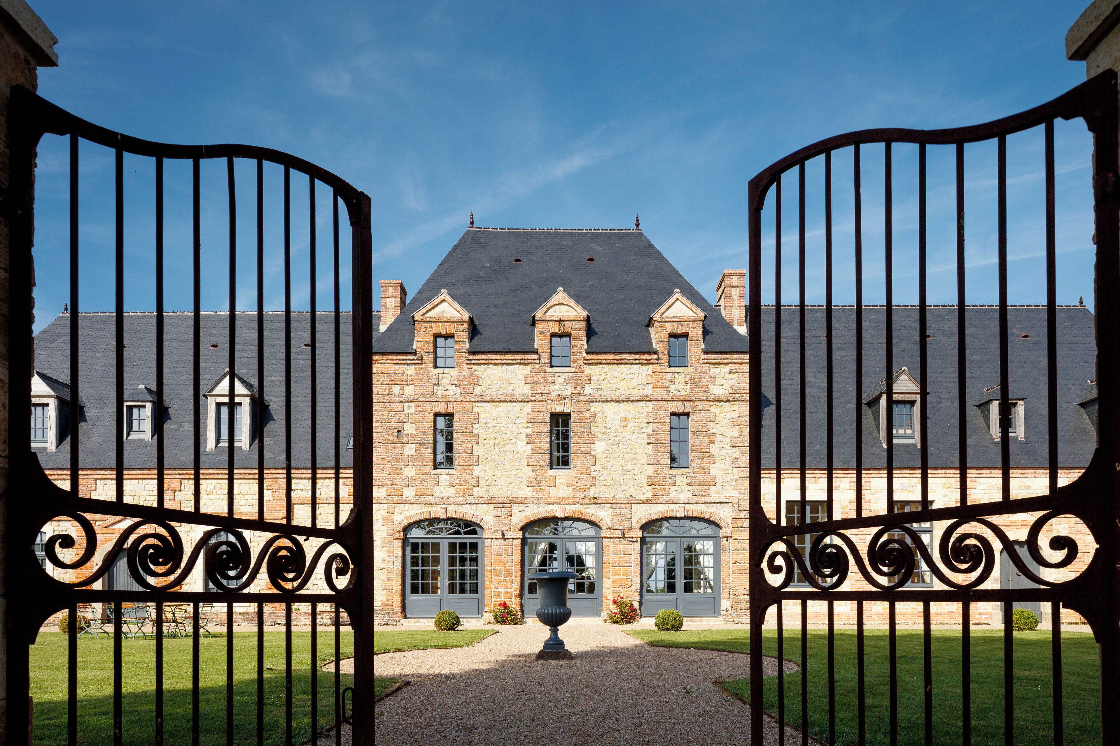 A large stone building with a symmetrical facade, multiple windows, and a central entrance.