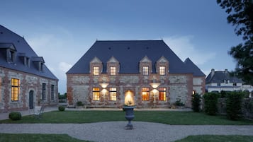 Vista frontal de la propiedad por la tarde o noche