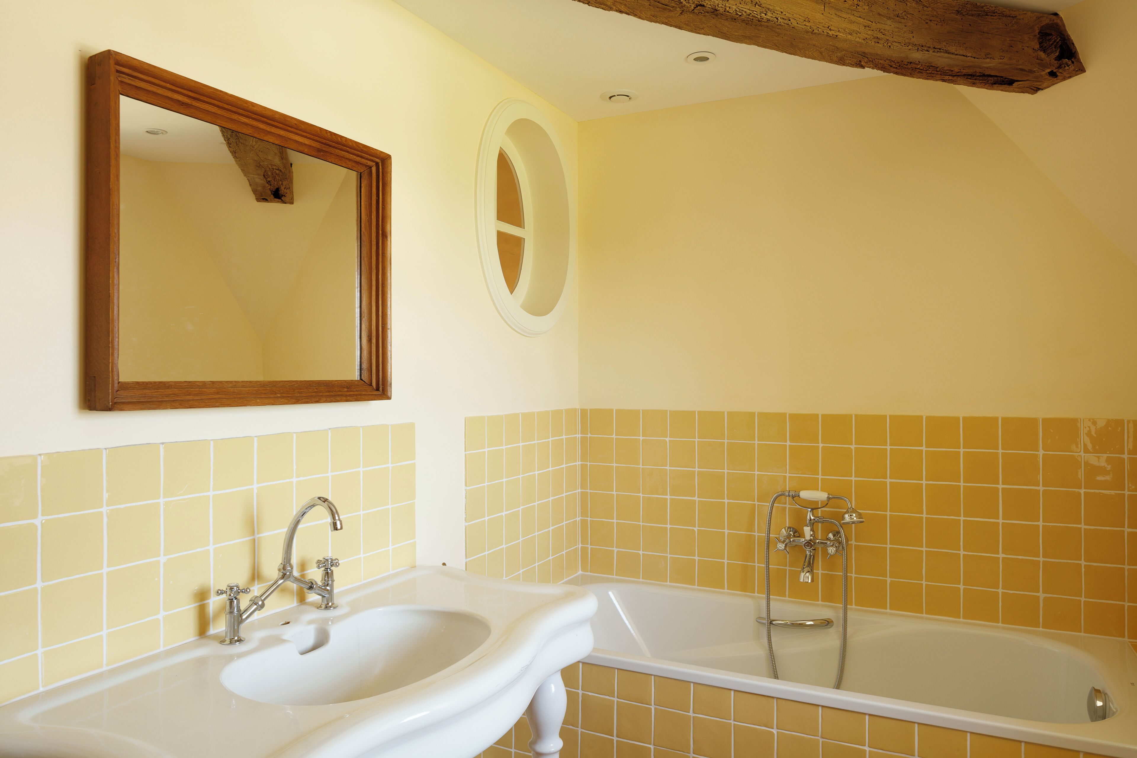 Un baño con lavabo, espejo y bañera.
