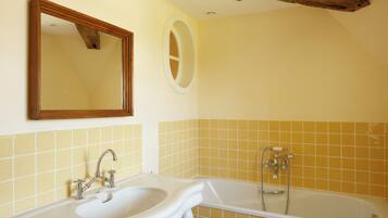 Un baño con lavabo, espejo y bañera.