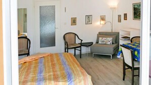 Une pièce comprenant un lit, une chaise, un canapé, un bureau et une lampe.