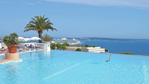 An infinity pool with a view of the sea and a cruise ship in the background. - Villa Francia by Interhome (Cannes)