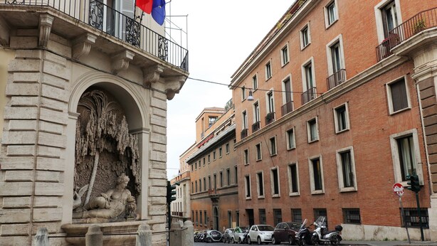 A street with parked cars and a building with a classical facade. - Trevi suites B&B (Rome)