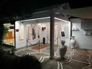 A hotel entrance with a glass door, a red carpet, and a sign indicating a sale. - Motel 24h (Lusciano)