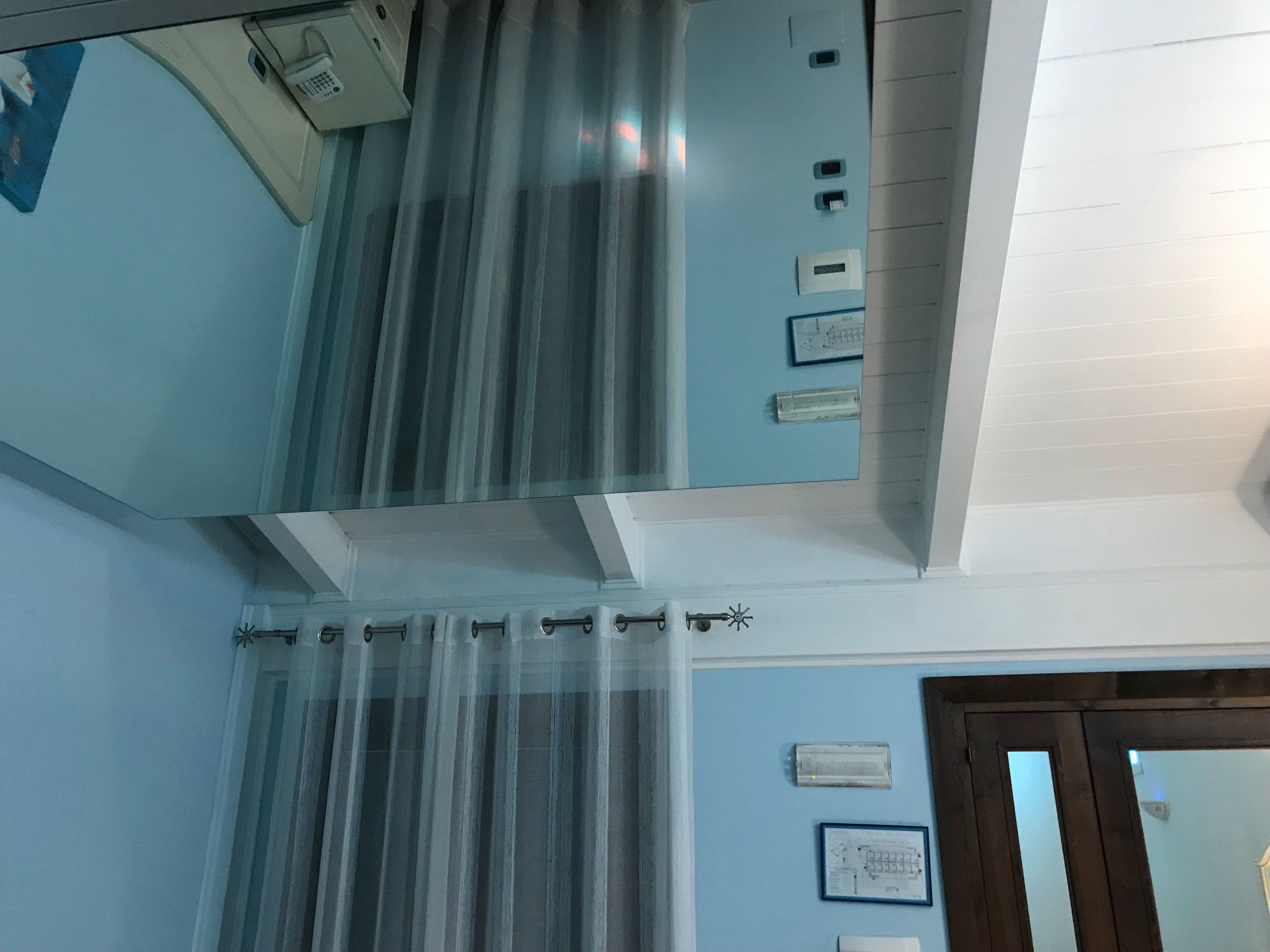 Un bagno con doccia, uno specchio e un portasciugamani.