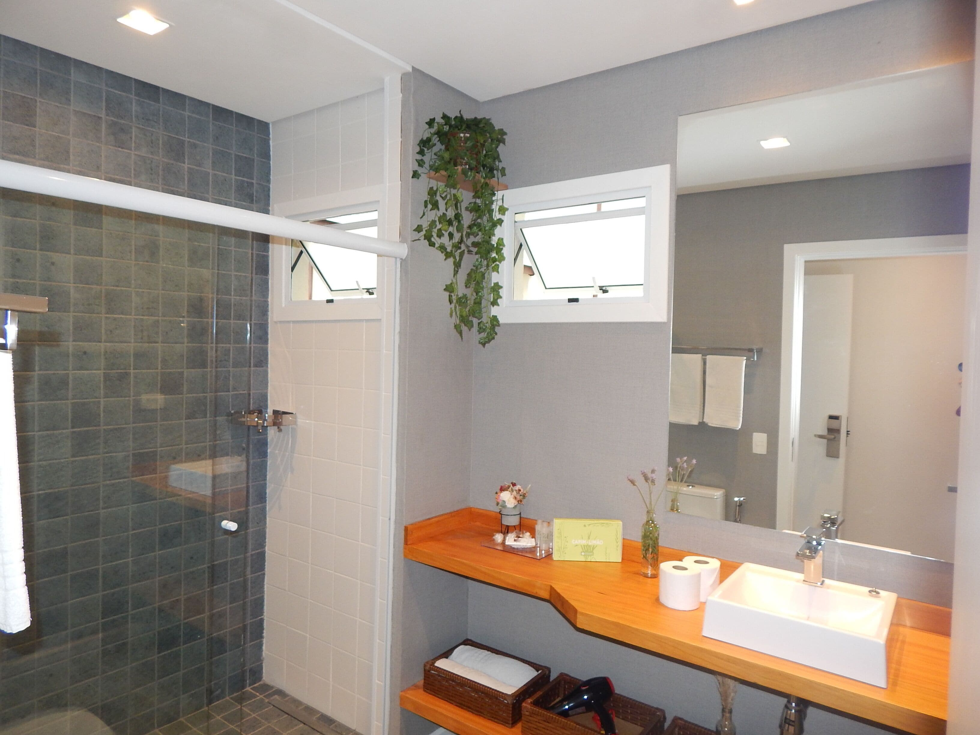 A bathroom with a shower, a sink, and a mirror.