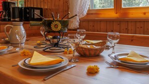 A wooden dining table set with plates, cutlery, and a teapot. - Notre Rêve by Interhome (Zinal)