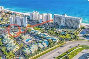 Un hôtel situé sur la côte, composé de plusieurs bâtiments, doté d’un parking et d’une piscine.