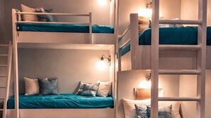 A bunk bed room with two levels, wooden flooring, and a ceiling fan. - Spacious, Relaxing, Family-Friendly Townhouse Retreat Steps from Pool & Beach (Destin)