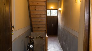 A narrow hallway with wooden walls, a wooden staircase, and a bicycle leaning against the wall. - Ferienwohnungen Stobenstrasse (Quedlinburg)