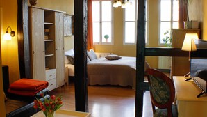 A room with a bed, a desk, a chair, a wardrobe, and a window with curtains. - Ferienwohnungen Stobenstrasse (Quedlinburg)