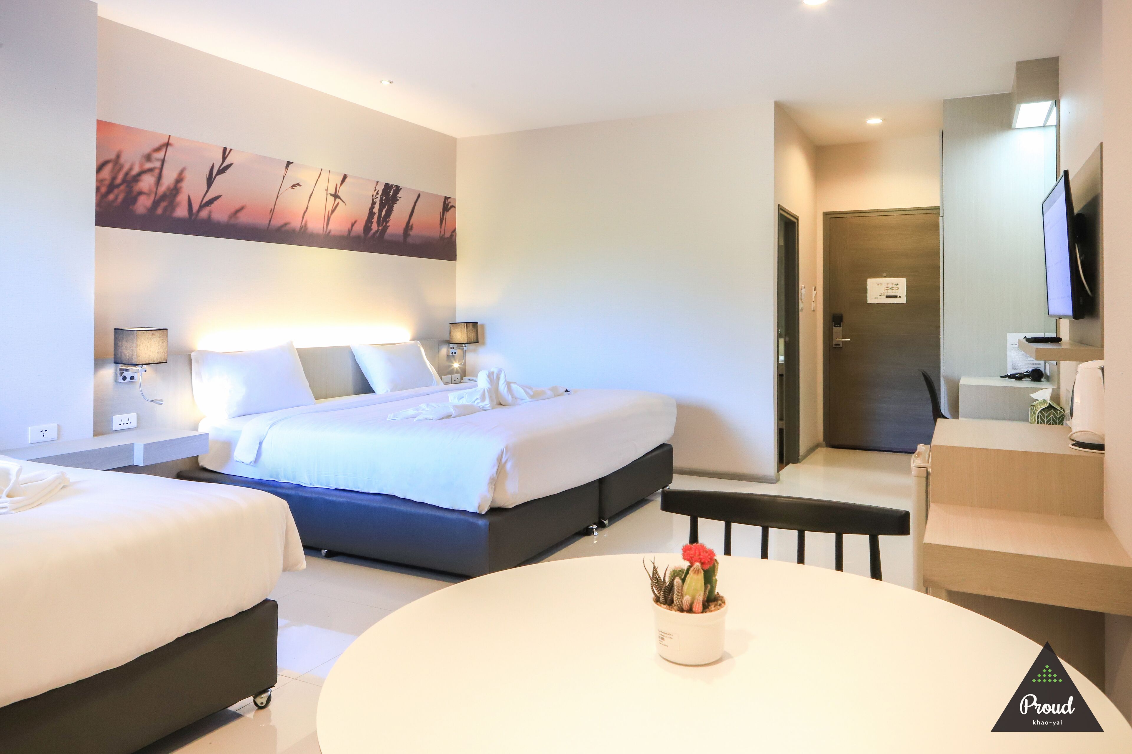 A hotel room with a bed, bedside tables, a desk, and a chair.