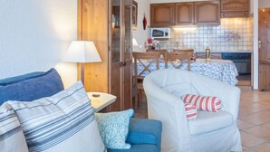 A compact living space with a kitchenette, a dining area, and a seating area with a sofa and armchairs. - Victoria 1 C1 by Interhome (Nendaz)