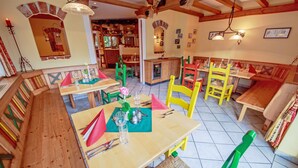 Ein Restaurant mit Holzbänken und -tischen, einem Fliesenboden und rustikalem Interieur.