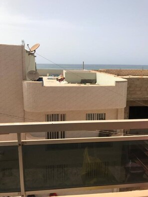 Ein Gebäude mit flachem Dach, Satellitenschüsseln und Blick auf das Meer.