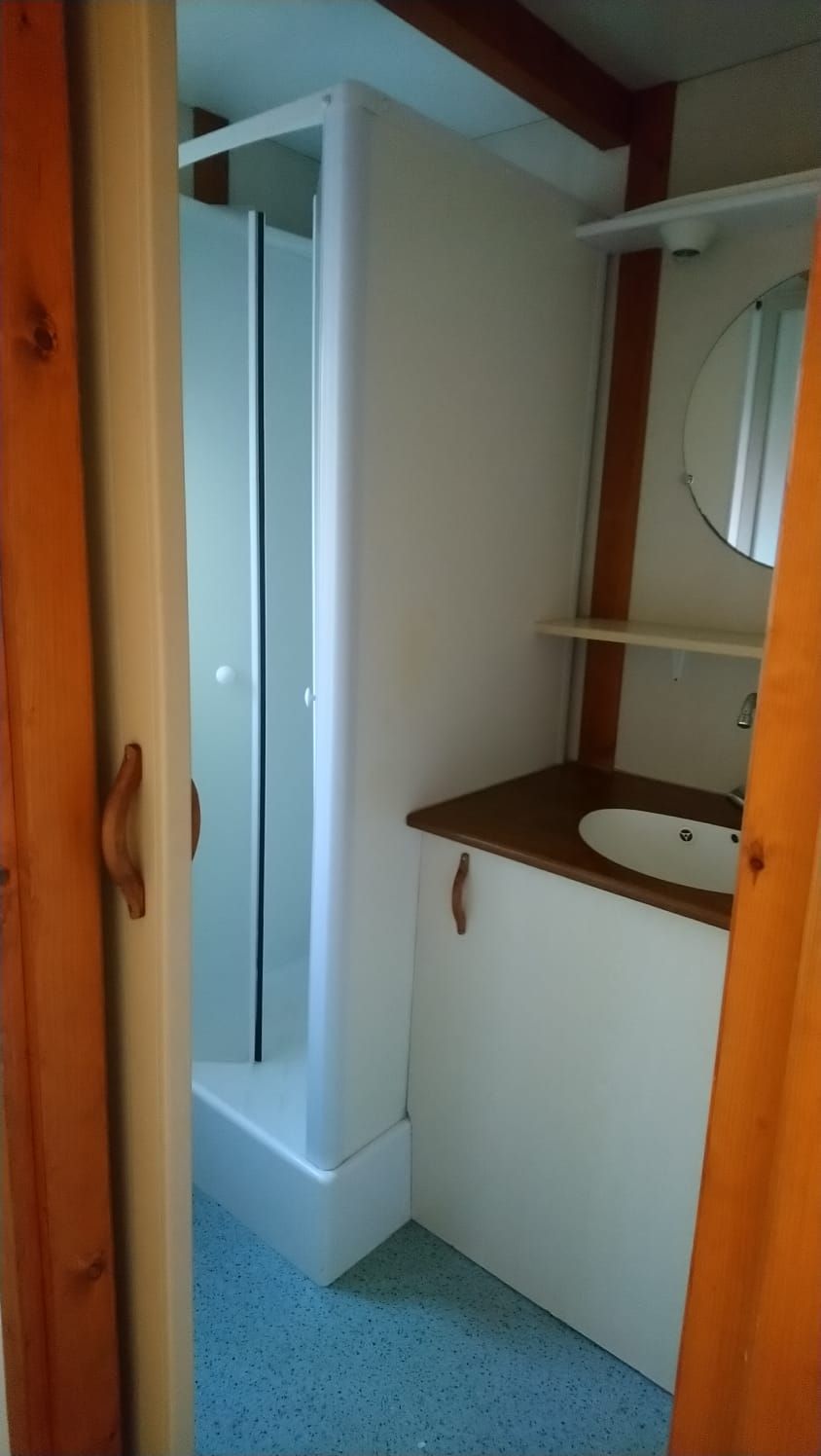 Un bagno con doccia, lavandino e specchio.