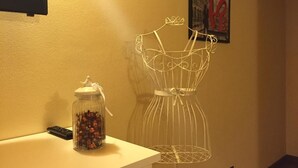 A room with a white counter, a decorative wire dress form, and a jar of candies. - Dimora 4 Spade (Verona)