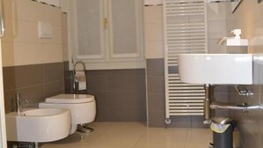 A bathroom with two sinks, a toilet, and a shower. - Dimora 4 Spade (Verona)