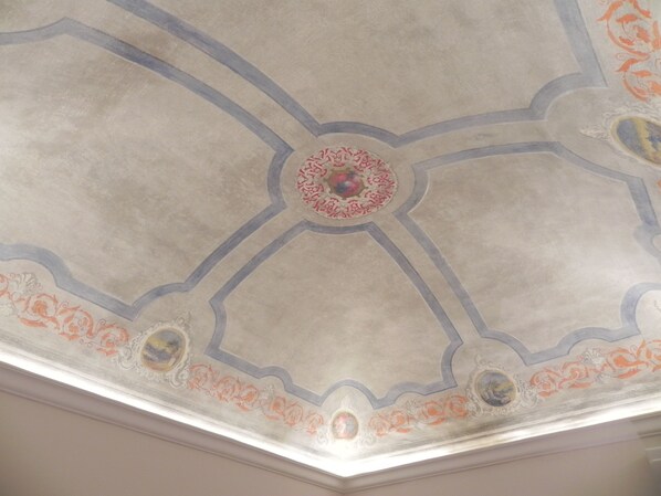 A ceiling with a geometric pattern and a central circular design.