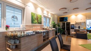 Una cocina moderna con montaje tipo bufé, armarios de madera y un comedor con sillas.