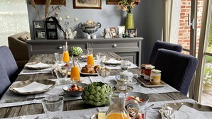 A breakfast table set with various dishes, including croissants, fruit, and orange juice. - B&B Aline Florentine (Kortenberg)